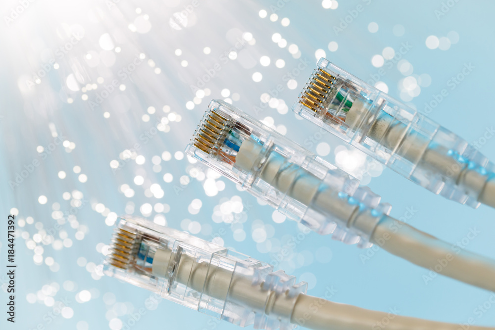 Closeup of RJ45 UTP LAN on the background of optical fibers with blurred lights