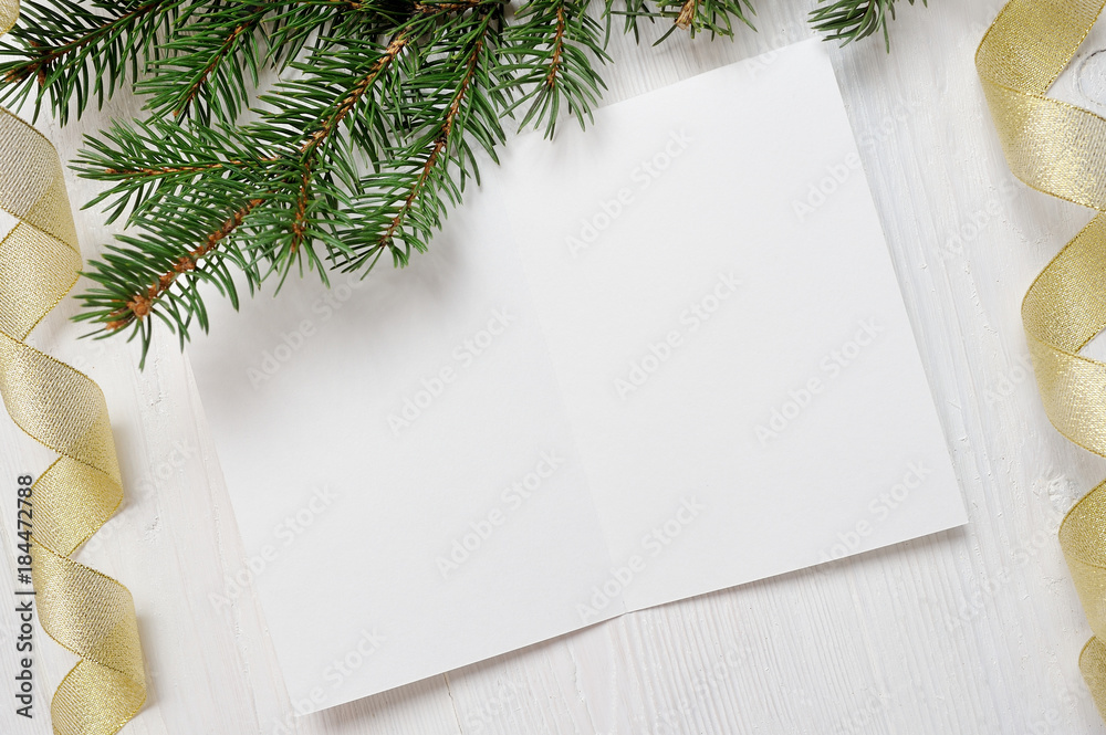 Mockup Christmas greeting card with tree and gold gift ribbon, flatlay on a white wooden background, with place for your text Mockup Christmas greeting card with tree and gold gift ribbon, flatlay on a white wooden background, with place for your text