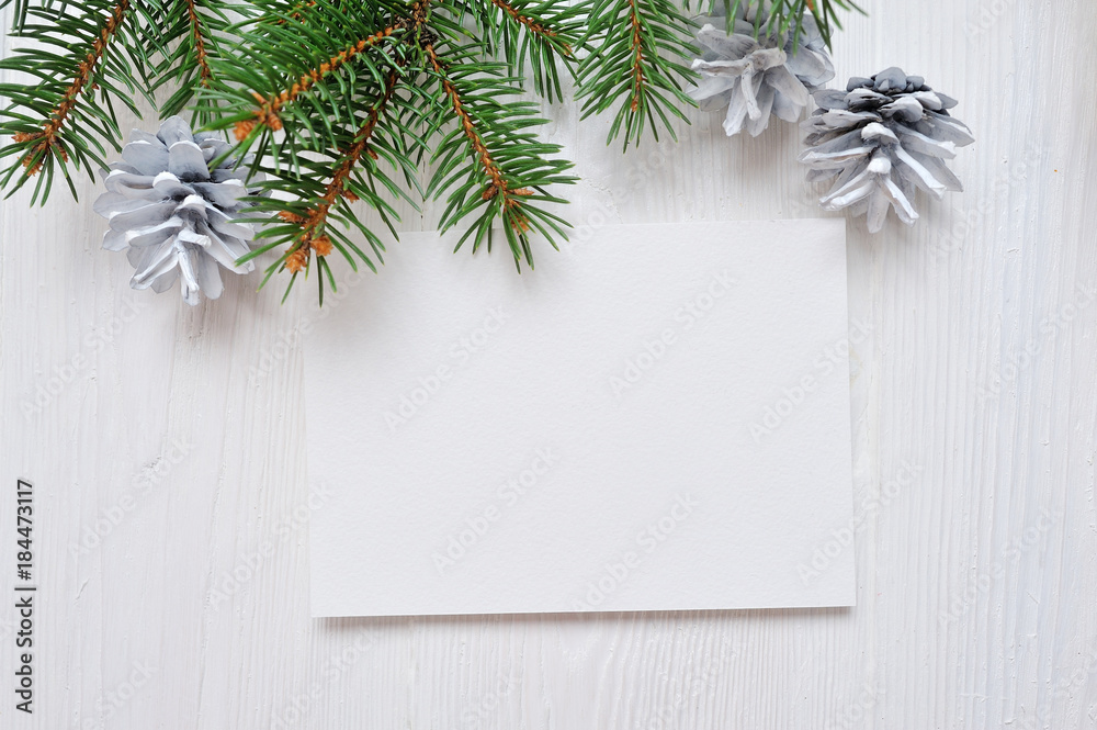 Mockup Christmas greeting card with tree and cone, flatlay on a white wooden background, with place for your text Mockup Christmas greeting card with tree and cone, flatlay on a white wooden background, with place for your text