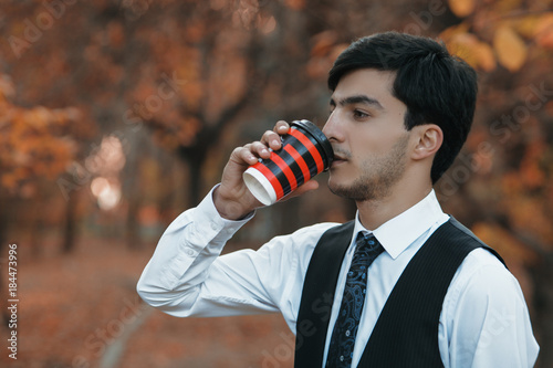 Man relaxing in nature with a coffee break, he drinking coffee at home and holding a cup photo