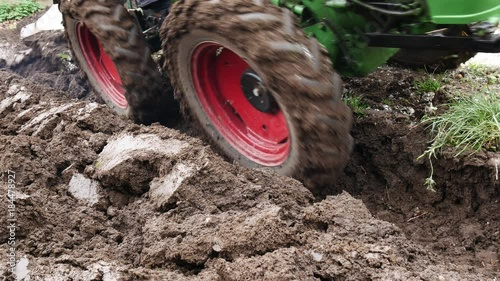 Detail of Small Tractor Ploughing a Field. No Camera Movement.