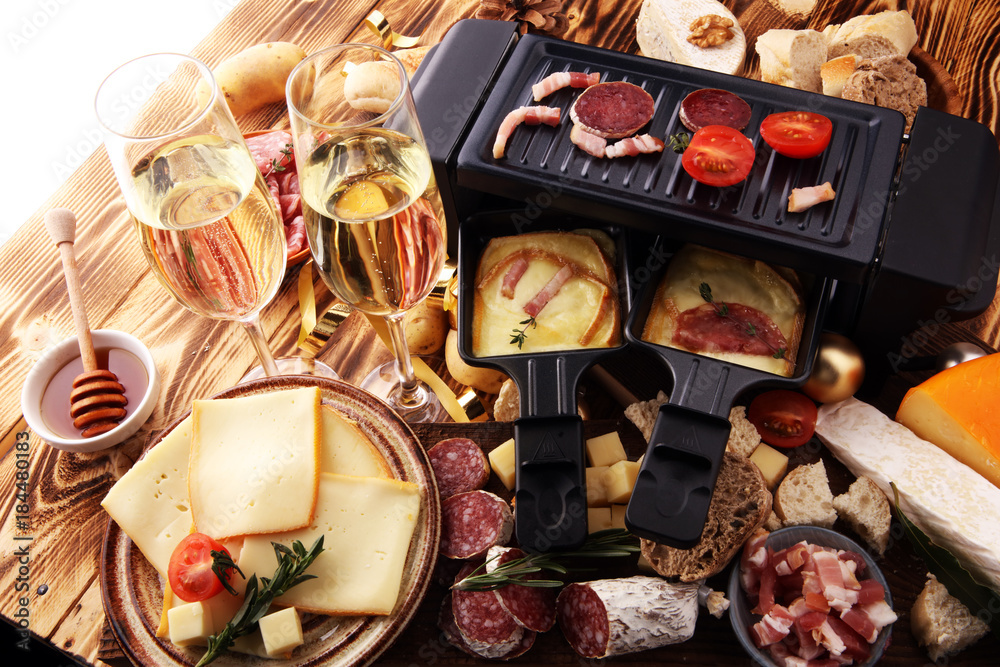 Φωτογραφία Delicious traditional Swiss melted raclette cheese on diced boiled or baked potato served in individual skillets