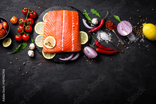 Fresh raw salmon red fish fillet on black background. Top view