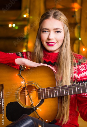 Girl with acoustic guitar in festive environment
