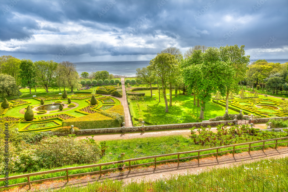Top view of green gardens of Dunrobin Castle in Scotland, United Kingdom. Dunrobin gardens have beautiful fountains, and labyrinth hedges. Scottish Highlands, Scotland, UK. Beautiful aerial view.