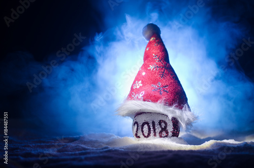 Red christmas balls with 2018 number and Santa Clause hat on natural snow background .Happy new year 2018 concept.Copy space.Selective focus. photo