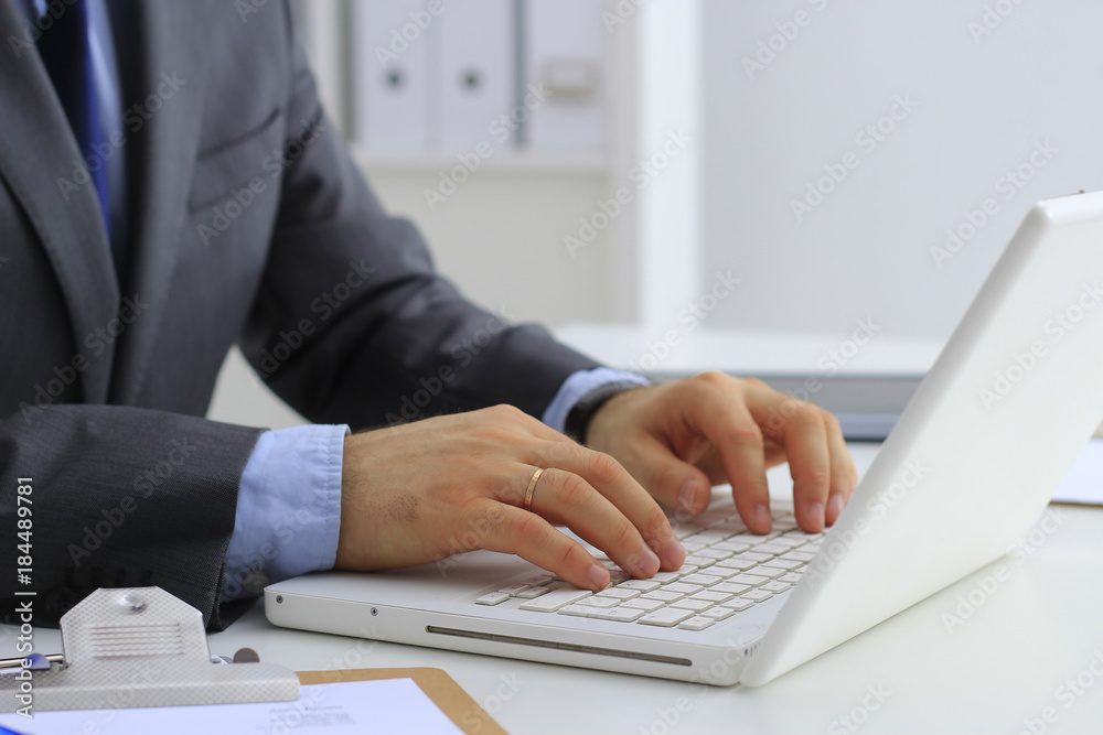 Handsome businessman working with laptop in office Handsome businessman working with laptop in office