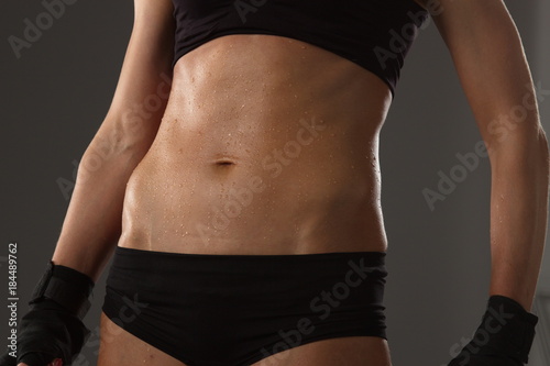 The body of a young athletic girl on dark background