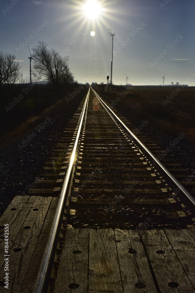 railroad track into the sun