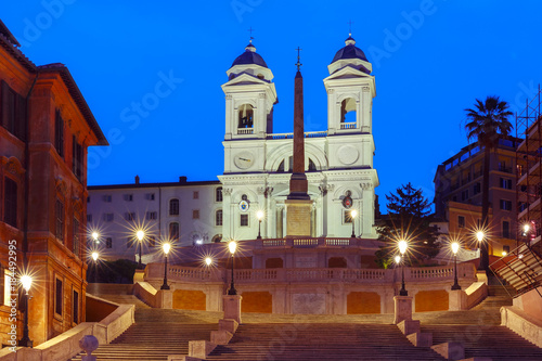 Monumental stairway Spanish Steps, seen from Piazza di Spagna, and Trinita dei Monti church during morning blue hour, Rome, Italy.