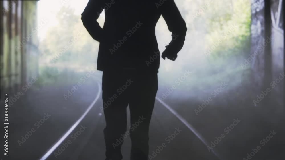Slow motion man running away on train track. Back view. Abstract background shot. Concept of chasing the misty future.