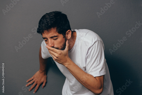 Portrait of young man drunk or sick vomiting photo