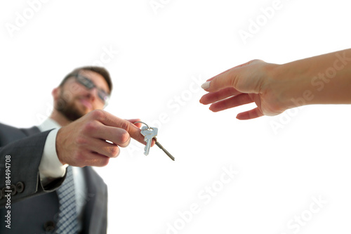 Cropped image of estate agent giving house keys to man in office