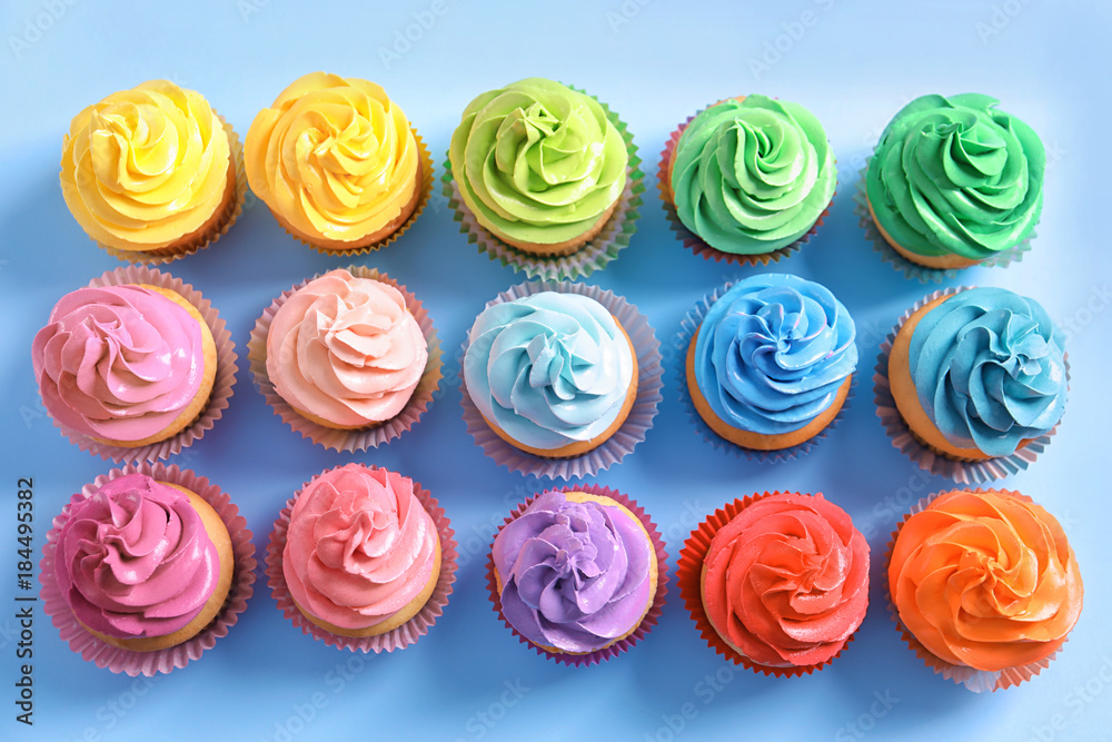 Delicious cupcakes on color background, top view Delicious cupcakes on color background, top view