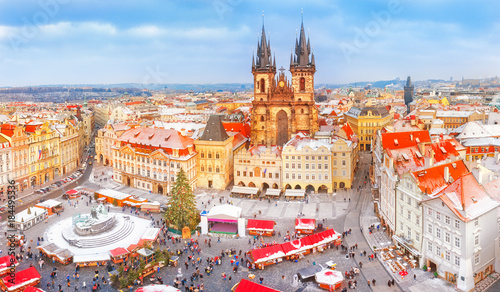 Prague in Christmas time, classical view on snowy roofs in central part of city and the Christmas market at old square at background of Tyn church. Seasonal winter landscape of Prague cityscape.