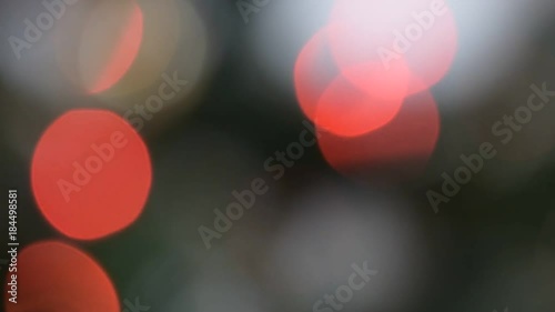 Horizontal pan of big blinking red bokeh lights on a Christmas tree