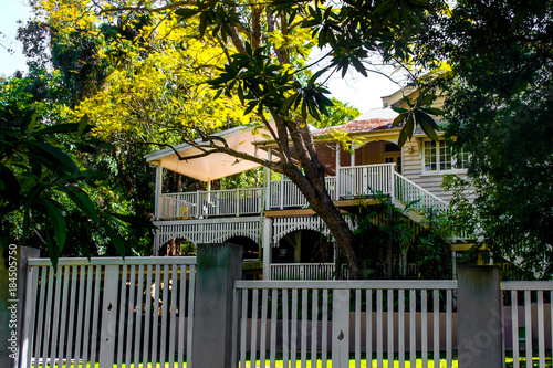 Traditional Australian Queenslander House with tropical foliage and wood and stairs