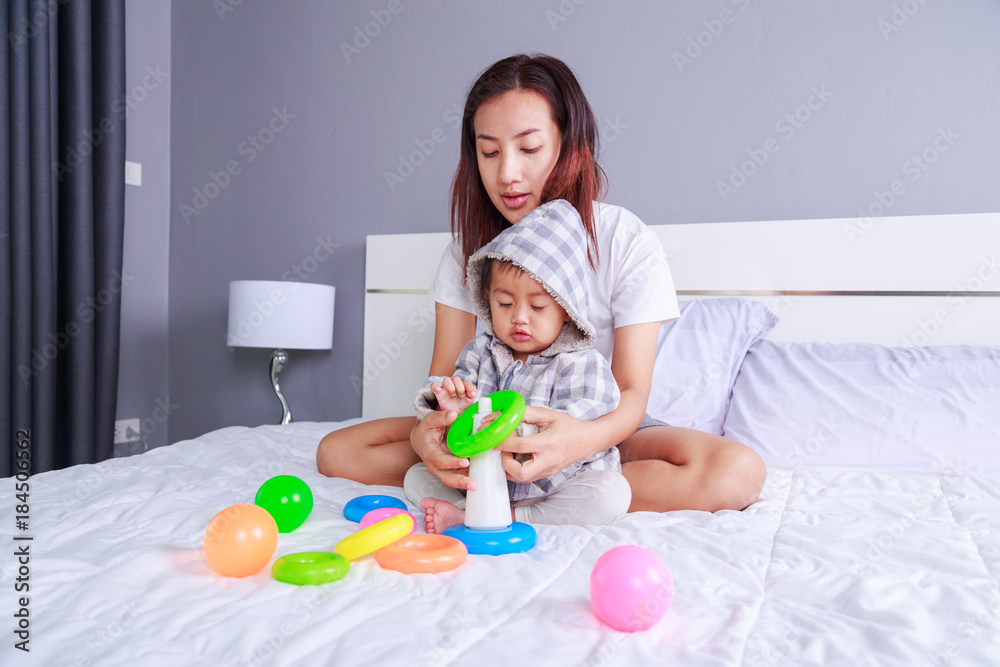 baby playing toys with mother on bed baby playing toys with mother on bed
