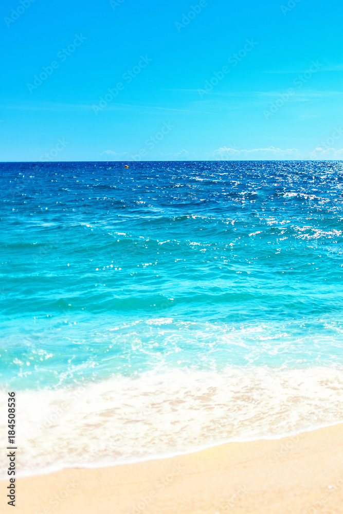 Soft wave of blue ocean on sandy beach Background with place for text. Tropical summer vacation concept.. Soft wave of blue ocean on sandy beach Background with place for text. Tropical summer vacation concept..