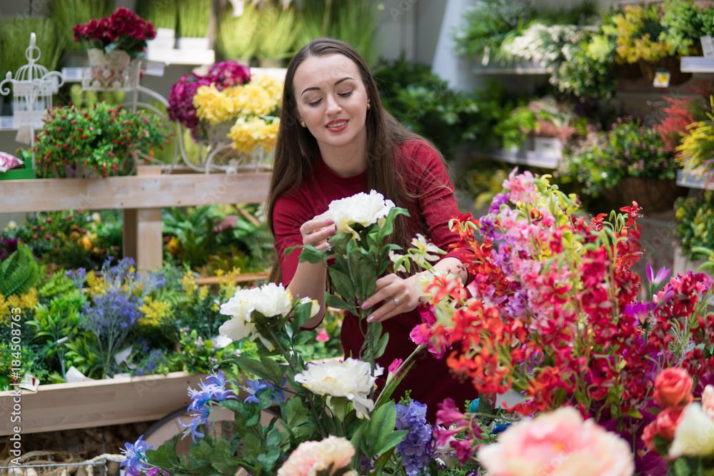 Beautiful woman buying flowers at flower shop. Happy women moments.