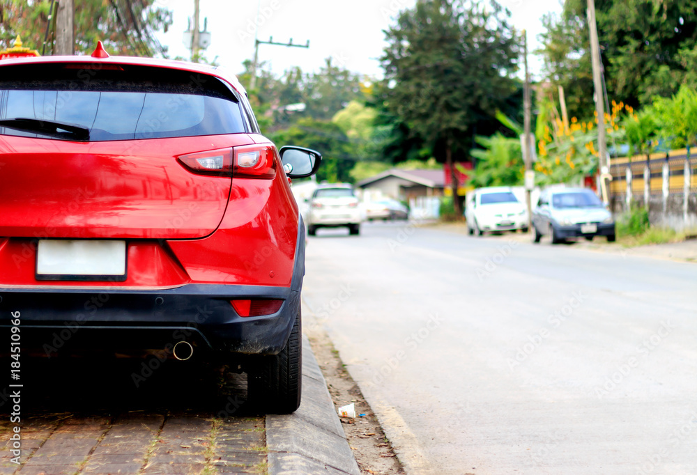 closeup red car on the road with soft-focus in the background and over light