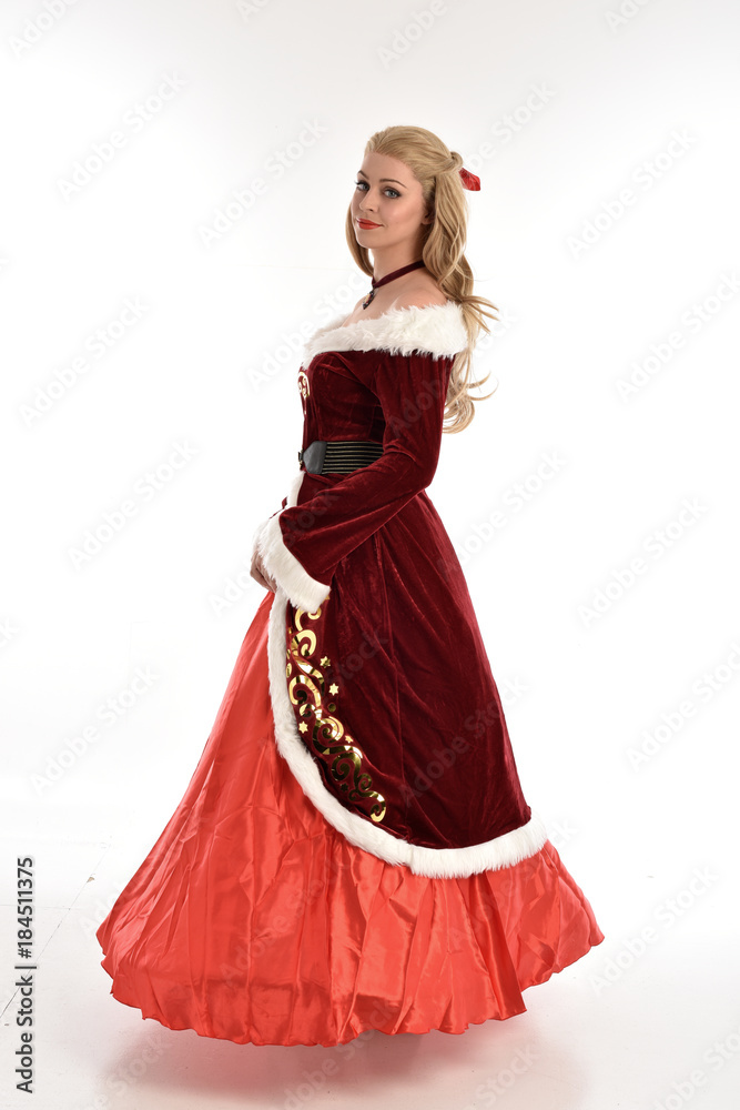 full length portrait of pretty blonde lady wearing red and white christmas inspired costume gown, standing pose on white background. full length portrait of pretty blonde lady wearing red and white christmas inspired costume gown, standing pose on white background.