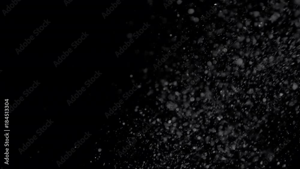 Several snow particles falling down over a black background that you ...