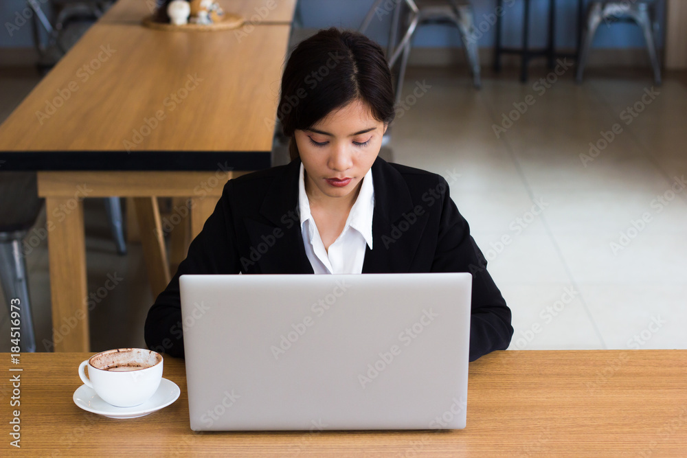 Business woman working by laptop with coffee on wood table in coffee shop or office. Business woman working by laptop with coffee on wood table in coffee shop or office.