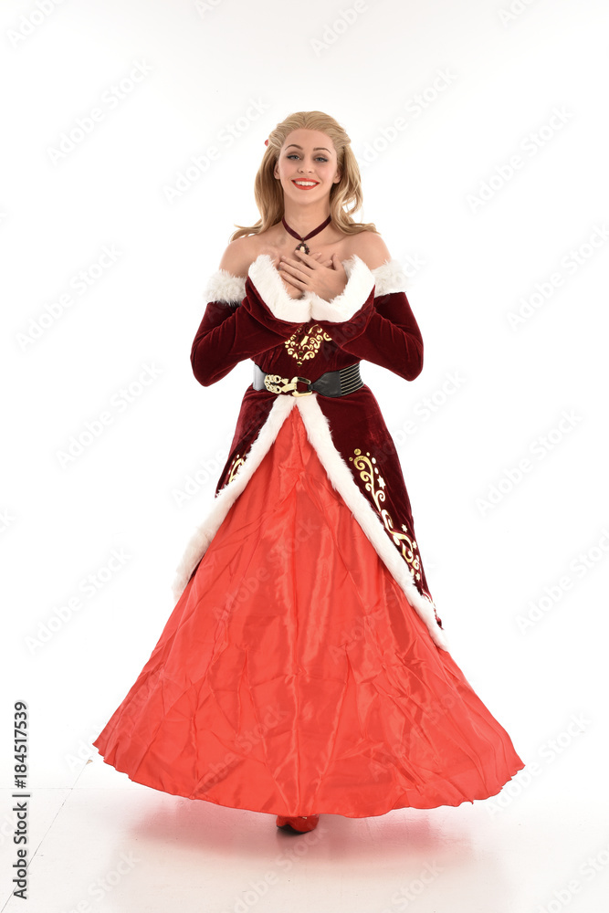 full length portrait of pretty blonde lady wearing red and white christmas inspired costume gown, standing pose on white background. full length portrait of pretty blonde lady wearing red and white christmas inspired costume gown, standing pose on white background.