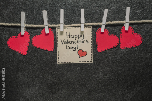 Cut out of red paper hearts hang on the rope on the little primako, greetings happy Valentine's day, top view photo