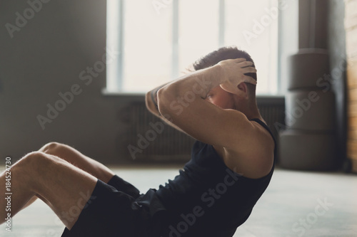 Young man fitness workout, sit-up crunches for abs photo