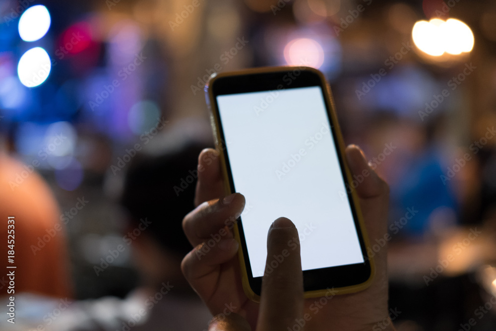 hand holding smartphone in pub. mobile phone with blank screen in restaurant hand holding smartphone in pub. mobile phone with blank screen in restaurant