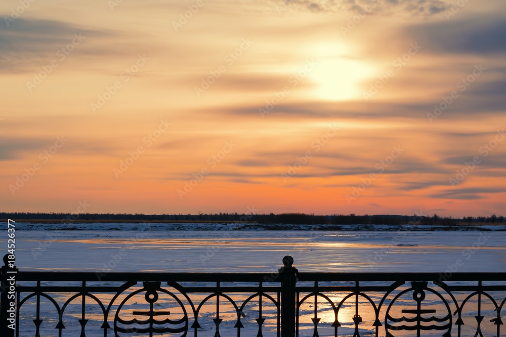 Beautiful sunset on the dark blue evening sky reflected on the river ice, winter landscape Beautiful sunset on the dark blue evening sky reflected on the river ice, winter landscape