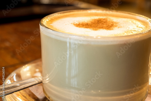 coffee cup with milk froth on wooden table