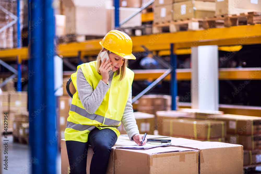 Woman warehouse worker with smartphone. Woman warehouse worker with smartphone.