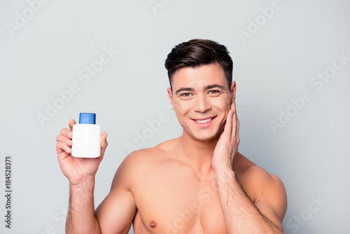 Canvastavla Portrait of happy excited cheerful satisfied pleased handsome guy showing a bott