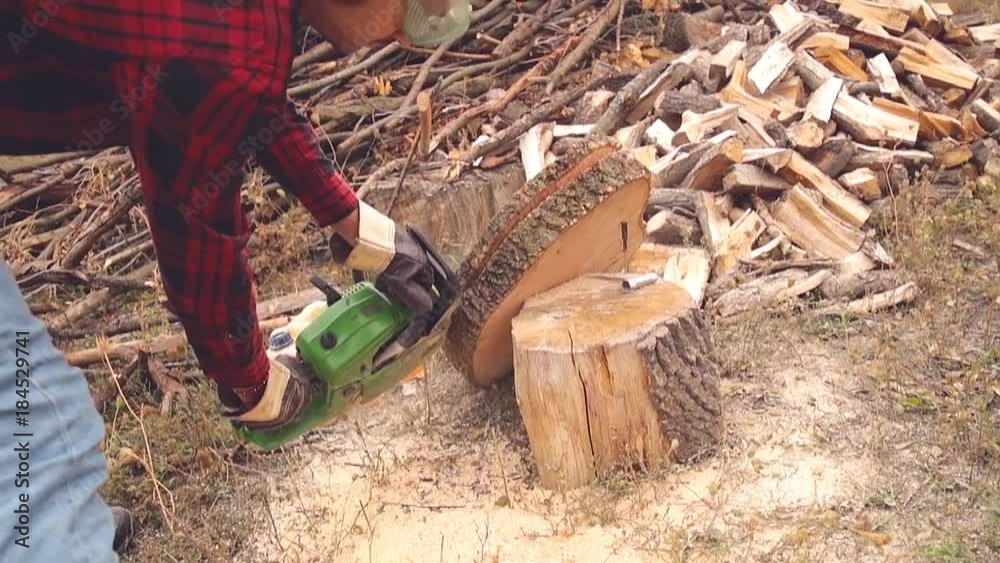 Lumberjack cutting woods with a chainsaw for winter. Lumberjack cutting woods with a chainsaw for winter.
