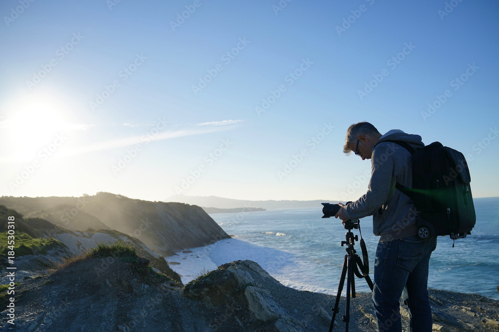 Photographer using tripod to take pictures of landscape