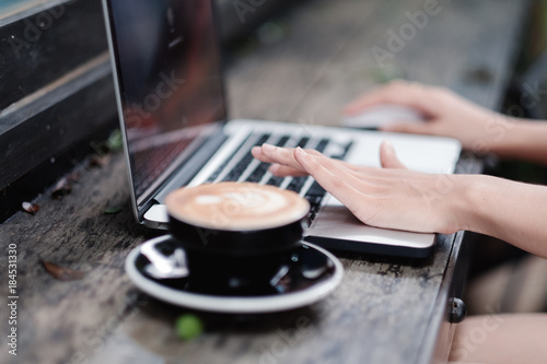 Woman hands typing on laptop keyboard at the office  Woman worker and business concept  Soft focus on vintage wooden table.