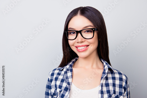 Close up of young smiling  woman in casual  clothing, standing over grey background. Education concept