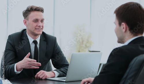 Manager sits behind the Desk and talks to the client © ASDF