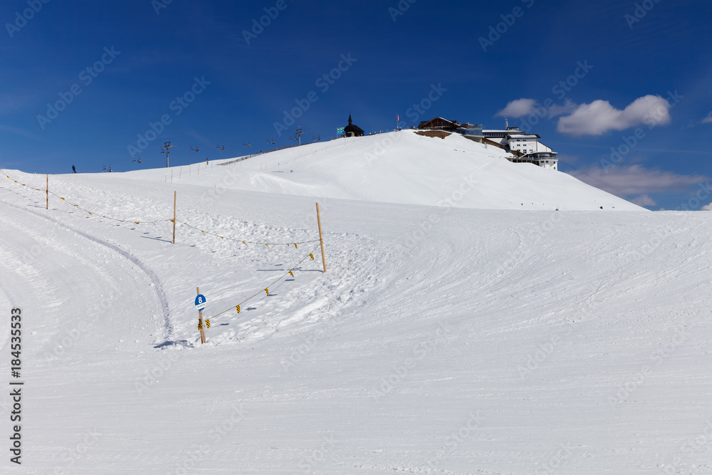 View to number 8 beginners blue ski slope at SCHMITTENHOHEBAHN 2000 meters peak with Elisabethkapelle on the top at Zell Am See Austria Alps mountain Schmitten resort