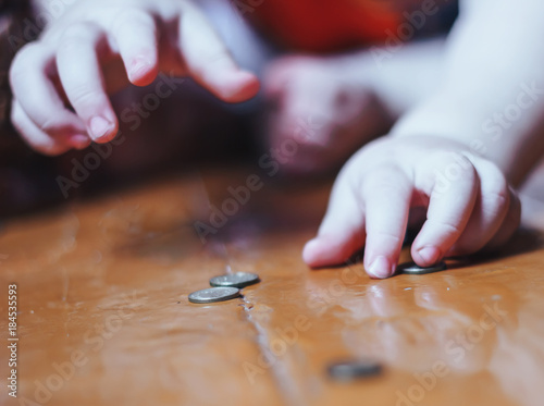 baby plays with coins on floor
