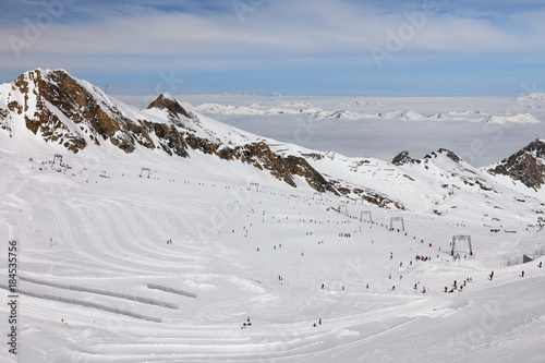 Austria, Zell Am See, Kaprun - March 21, 2017:  Highest high-altitude Kitzsteinhorn glacier ski slopes and lifts with foggy Alps Mountains, blue sky and clouds in background at Austrian ski resort