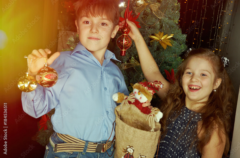 Happy little kids decorate Christmas tree in beautiful living room with traditional fire place. Happy little kids decorate Christmas tree in beautiful living room with traditional fire place.