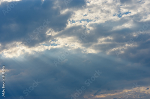 The sun's rays against the blue sky make their way through clouds and clouds © Nadia