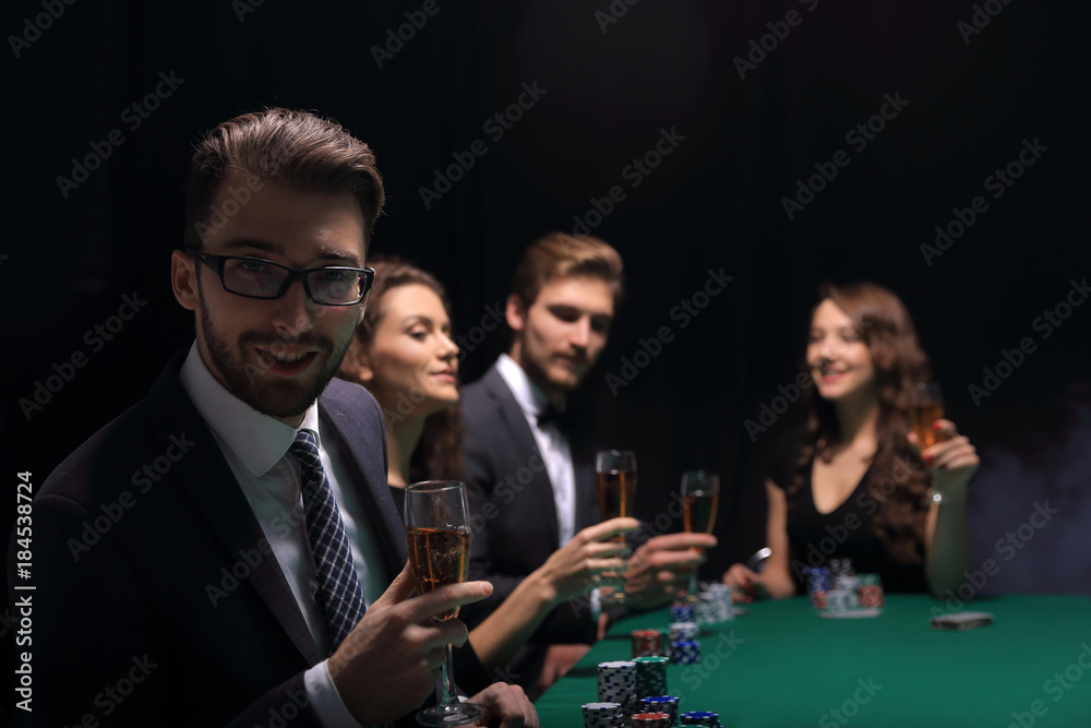 poker players with a glass of wine ,sitting at a table poker players with a glass of wine ,sitting at a table