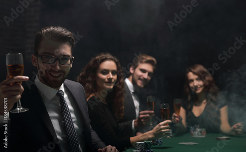 poker players with a glass of wine ,sitting at a table
