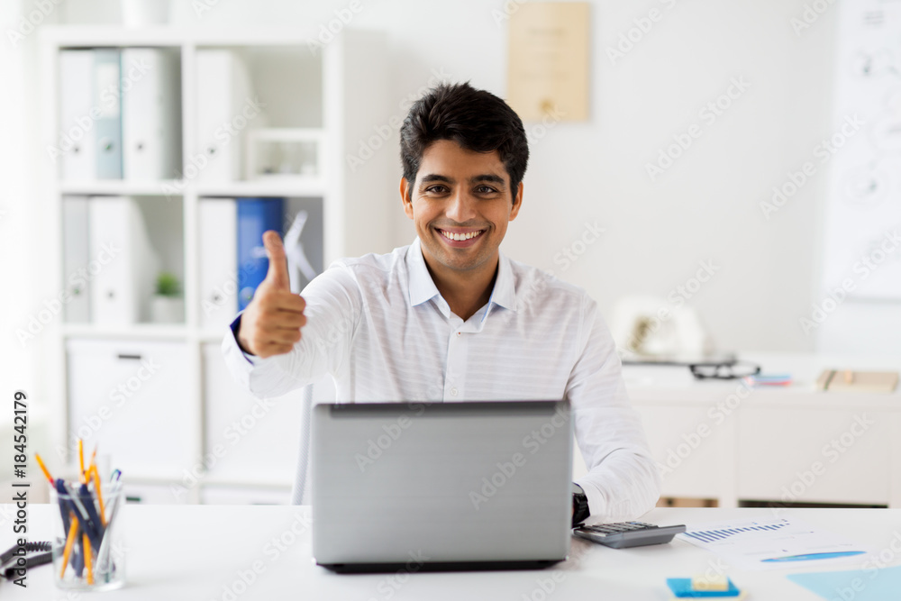 businessman showing thumbs up at office