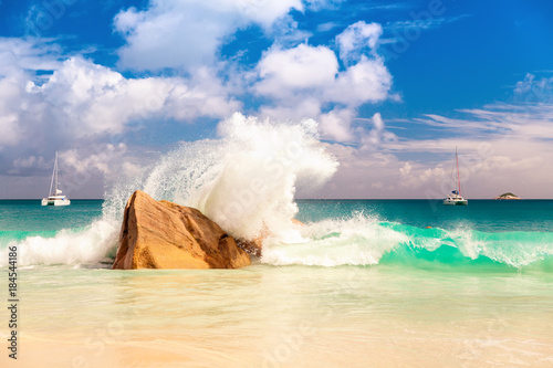 Fototapeta Naklejka Na Ścianę i Meble -  Big sea wave breaking on the shore rock with stunning blue ocean water on background